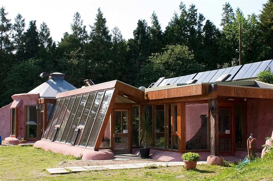 Earthship home exterior — sustainable architecture built with recycled tires, glass, and earth