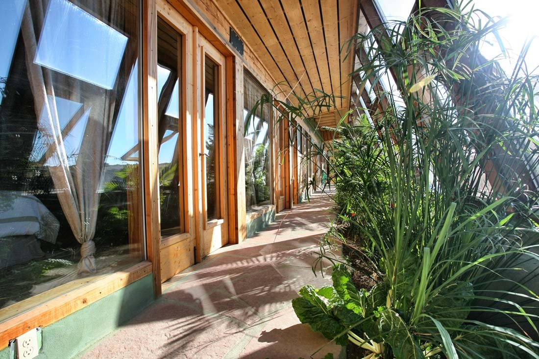 Earthship interior living space showing natural materials, recycled bottle walls, and earthy aesthetic